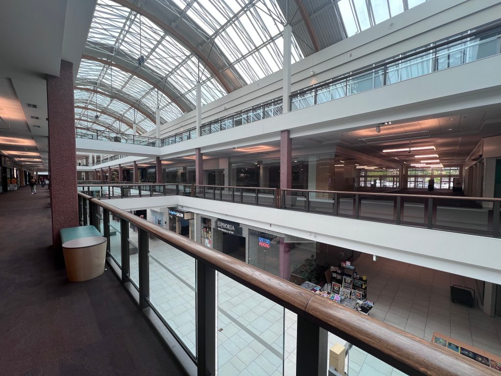 Spacious indoor shopping mall with a skylight roof in Portland, Oregon, showcasing modern architecture.